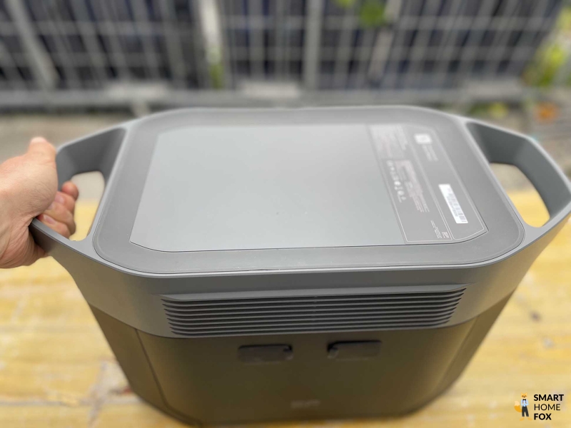Der EcoFlow DELTA 2 Max wird im Test an dem Tragegriff gepackt.
